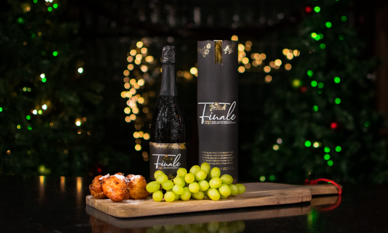 Grolsch Finale fles met kerstversiering op de achtergrond